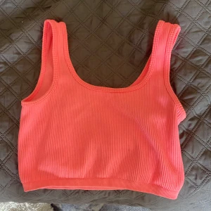 Ribbad rosa linnetopp från FB sister XS - Säljer en ribbad rosa linnetopp med breda axelband och croppad passform. Toppen har en enkel och stilren design med rundad halsringning och är perfekt för varma dagar. Materialet är stretchigt och bekvämt.