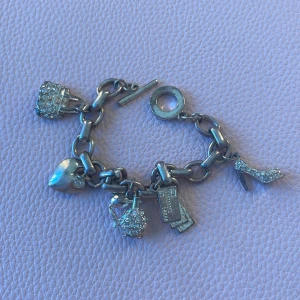 Silver armbande, denna säljer jag bara för en riktig baddie - Charmigt armband i silverfärg med stora länkar och fem berlocker: en glittrig väska, ett hjärta, en glittrig parfymflaska, kreditkort och en glittrig högklackad sko. Perfekt accessoar för dig som gillar ” sticka ut”.  Älskar detta, har alltid fått komplimanger av den. Men tänker den få gå vidare för någon annan baddie nu. 