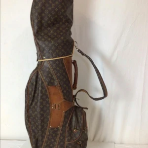 Louis Vuitton golfbag i monogram canvas - Exklusiv golfbag från Louis Vuitton i klassisk brun monogram canvas med detaljer i ljust brunt skinn. Väskan har axelrem, handtag och flera fickor med dragkedja. Perfekt för dig som vill sticka ut på golfbanan med lyxig stil.
