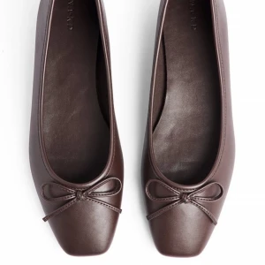 Bruna ballerinaskor med rosett - Stilrena bruna ballerinaskor med fyrkantig tå och söt rosettdetalj framtill. Skorna är helt nya och oanvända. 