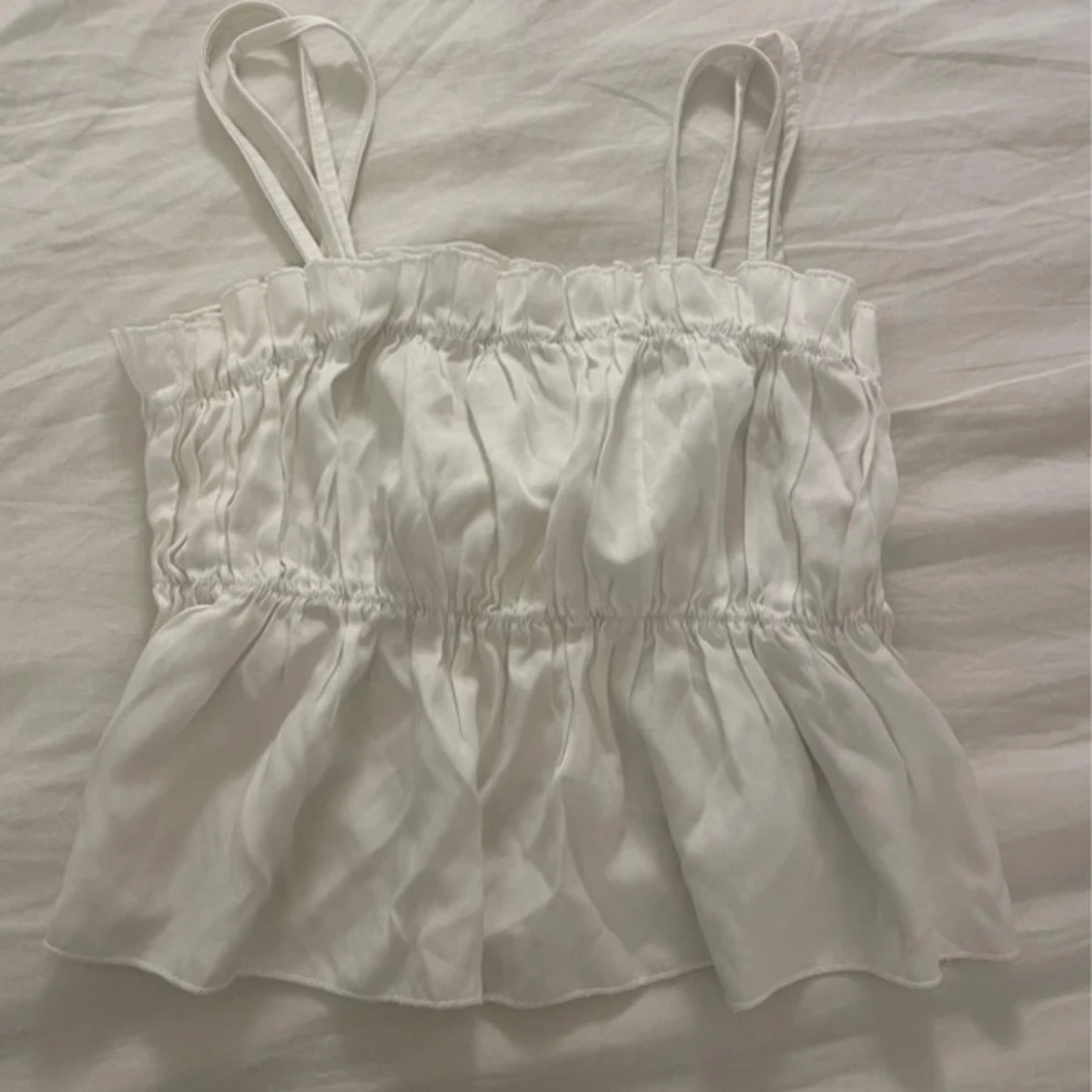 Vit ärmlös topp med volangdetaljer