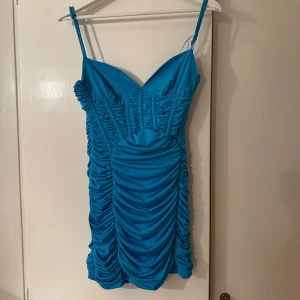 Blå klänning från zara - Snygg blå klänning med smala axelband och rynkade detaljer. Perfekt för en utekväll eller något lite extra! Sitter tight och framhäver figuren på ett fint sätt. Det är en liten defekt på ena sidan av axelbandet, men det går superlätt att sy ihop och märks inte när man har den på. I övrigt i bra skick! Pris kan diskuteras 🌸💕 