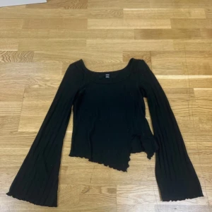 Svart långärmad ribbad topp från SHEIN M - Säljer en svart ribbad topp från SHEIN med lång ärm och croppad passform. Toppen har utsvängda ärmar och en rundad halsringning. 