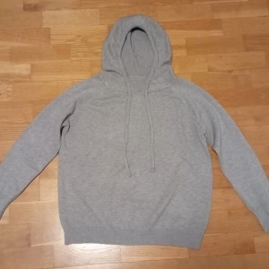 Grå merinoull hoodie  - Säljer en stilren grå merinoull hoodie med långa ärmar och justerbar huva. Perfekt för en avslappnad look. Den har ribbade muddar vid ärmslut och nederkant för extra komfort. Hör av dig ifall du har några frågor. Pris kan diskuteras.