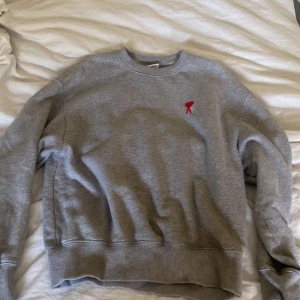 Ami sweatshirt - Fin Ami sweatshirt i en mycket fin grå färg, går med allt. Har växt ur den och därför jag säljer den. Den är i bra skick och inga fel på den vad jag vet.