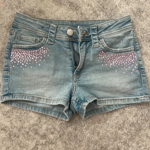  jeansshorts - Snygga ljusblå jeansshorts med rosa diamanter. från hm 