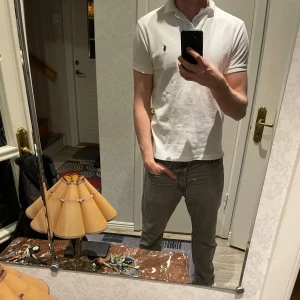 Vit piké från Ralph Lauren - Klassisk vit pikétröja från Ralph Lauren med korta ärmar och krage. Tröjan har en liten broderad logga på bröstet och är tillverkad i mjuk bomull. Perfekt för en stilren och avslappnad look. Riktigt fet och passar till allt, perfekt nu till våren/sommaren.🍾