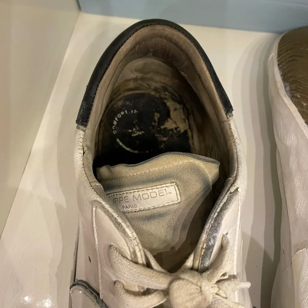 Snygga vita sneakers från Philippe Model med svarta detaljer och snörning. Skorna har en klassisk design med rund tå och är perfekta för en stilren look. Men dom är lite slitna och behöver sig en uppfräschning så som sulan under skon och den har creasningar därav pris…. Kengät.