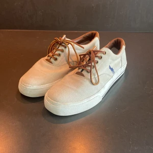 Beige sneakers från Polo Ralph Lauren - Snygga beige sneakers från Polo Ralph Lauren i bra skick