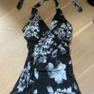  halterneck linne - Säljer en svart söt halternecktopp med vita blommor och omlottkänsla. Linnet har  v-ringning och knyts i nacken. Materialet känns mjuk, perfekt för sommarens varma dagar. S/xs 💓