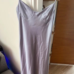 Ljuslila långklänning i satin - Säljer en ljuslila långklänning i satin från Zara med smala axelband och öppen rygg. Klänningen har en slät och glansig yta och använd 1 gång. Hör av dig för flera bilder eller frågor 💕