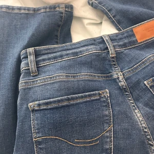 Blå jeans från Vero Moda - Snygga blå jeans från Vero Moda med klassisk femficksdesign och knappgylf. Perfekta för en avslappnad stil med en bekväm passform. Dom är inte bootcut men dom är utsvängda nertill!!!