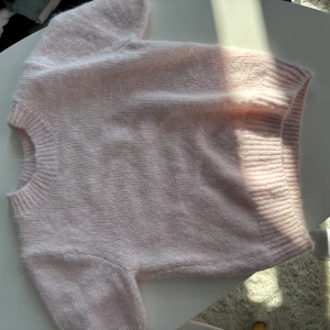 Ljusrosa stickad tröja från Gina Tricot - Supermjuk ljusrosa stickad tröja från Gina Tricot. Tröjan har korta ärmar och lite ”resår” i ärmsluten!💕💞 aldrig använd!  
