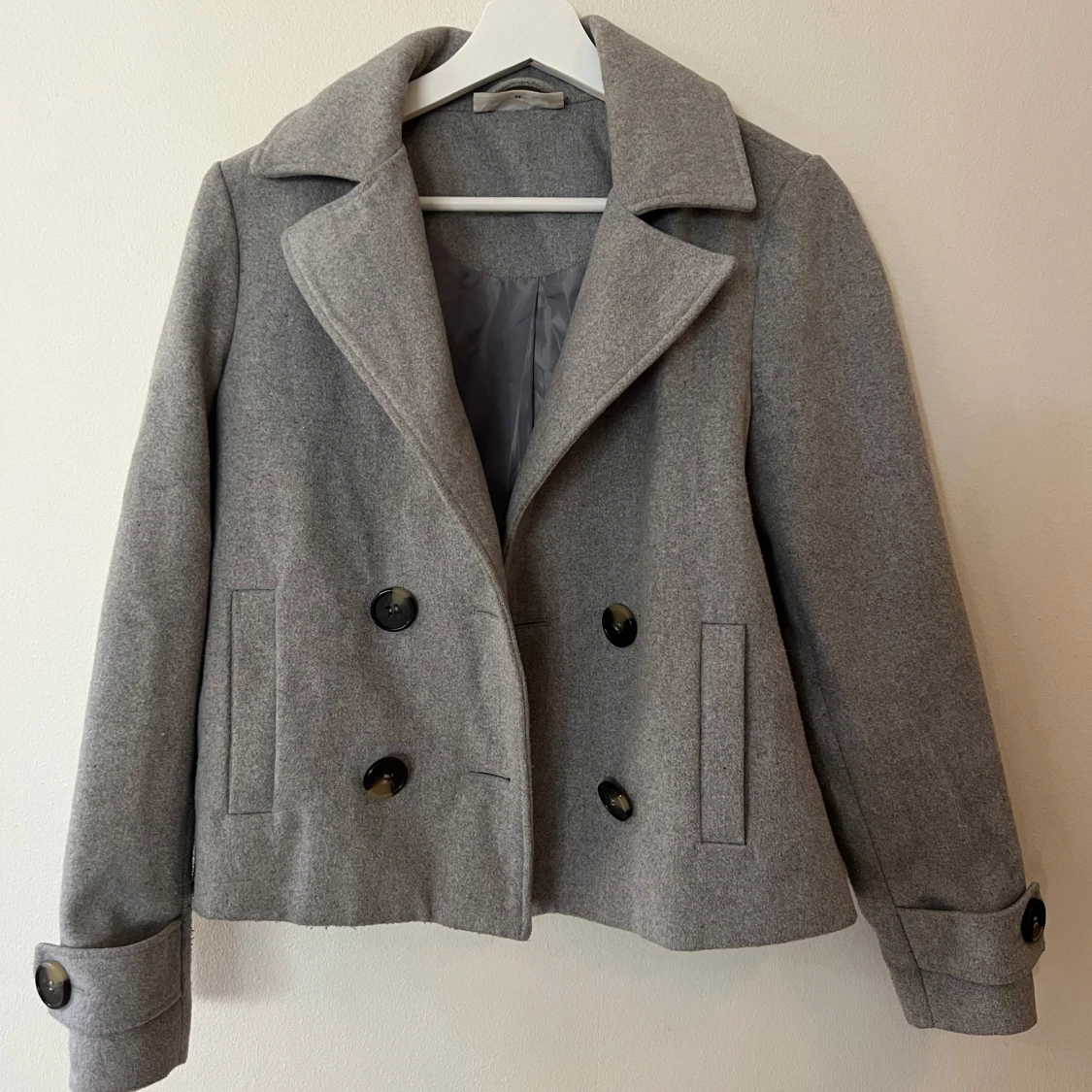 Grå kappa med knappar