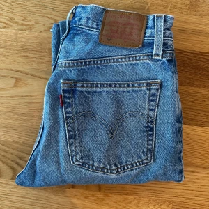 Levi's 501 blå jeans W24 L28 - Klassiska Levi's 501 jeans i ljusblå denim med raka ben och medelhög midja. Inga skavanker. 