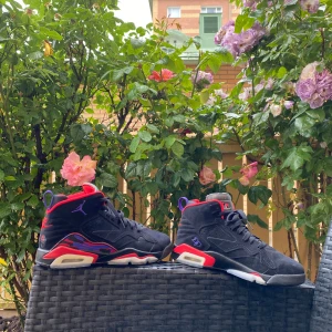 Nike Air Jordan 6 Retro Svart/Röd - Säljer ett par Nike Air Jordan 6 Retro i svart mocka med röda och lila detaljer. Skorna har en hög siluett, snörning och ikonisk Jumpman-logga på sidan. Sulan har coola grafiska mönster i rött och lila samt genomskinliga partier. Perfekta för dig som vill sticka ut.