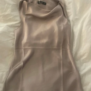 Champagnefärgad sidenblus från Mango - Supersnygg ärmlös blus från Mango i en lyxig champagnefärg. Toppen har en draperad halsringning och är gjord i ett glansigt sidenliknande material som känns riktigt exklusivt. Perfekt att styla med jeans eller kjol för en trendig look. Den hade varit snygg till svarta lädershorts!! Helt ny bara testad. 🩷