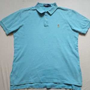 Blå Ralph Lauren piké  - Tjo gubbar! En fet Ralph Lauren piké i fin blå färg med märket i orange. Väldigt bra skick, storlek L och perfekt för just dig 😉 kolla gärna profilen för mycket mer Ralph Lauren kläder och följ gärna också ❤️ ha de göttttttt 🥳
