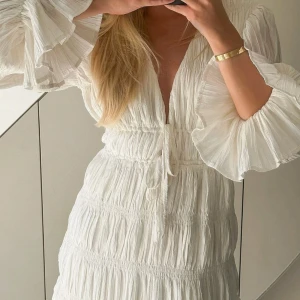 Strukturerad miniklänning med knytdetalj - Jättefin vit klänning från NA-KD! Aldrig använd och är därmed i mycket bra skick. Tveka inte på att höra av dig om du vill se fler bilder eller har någon fråga! 💞