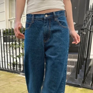 Blåa wide jeans med hög midja - Säljer ett par klassiska blå jeans med hög midja och breda ben. Jeansen har fem fickor, raka sömmar och en avslappnad passform. Perfekta för dig som gillar en loose och trendig look. Materialet är robust denim i bomull.