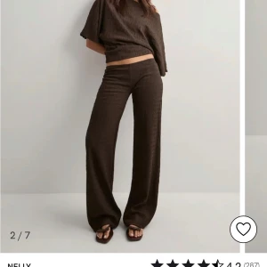 Bruna vida byxor från Nelly - Mörkbruna byxor med breda ben och hög midja från Nelly. Byxorna har en lätt textur i materialet och sitter löst för en chill och trendig look. Perfekta att matcha med crop top eller oversized tröja.