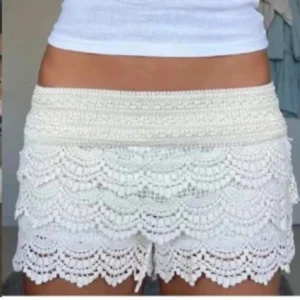 Vita virkade shorts med volang - Superfina vita virkade shorts med flera lager volang och snyggt mönster. Perfekta till sommaren och ger en bohemisk vibe. De har bred midja och sitter skönt på höften. Lätta att matcha med crop tops eller linnen. Aldrig använda säljer då de va lite stora på mig skriv för fler bilder 