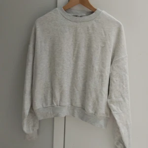 Grå tjocktröja  - Grå tjocktröja från Divided / H&M i hoodie liknande material som är jättemjukt. Har lite stretch i både material och ändarna på armarna ( se bild 3 ). Har en liten fläck på magen men syns knappt.  Säljer då den inte kommer till användning! Pris kan diskuteras!! 