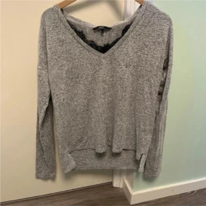 Grå v-ringad stickad tröja - Mysig grå stickad tröja med v-ringning och långa ärmar. Perfekt för kyliga dagar och enkel att matcha med jeans eller kjol. Tröjan har en avslappnad passform och känns supermjuk mot huden.