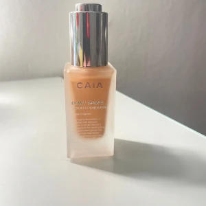 CAIA Dewy Drops Serum Foundation 30N - CAIA Dewy Drops Serum Foundation i nyansen 30N. Kommer i en frostad glasflaska med silvrig kork och pipettapplikator. Ger en naturlig, återfuktande finish med vitamin E och glycerin. Perfekt för dig som vill ha en fräsch och glowig bas.helt ny och oanvänd.säljer pågrund av att färgen inte passar.