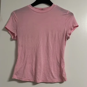 Ljusrosa t-shirt i bomull, stl S - Enkel och stilren ljusrosa t-shirt i mjuk bomull. Sitter mer på tajtare sidan men är extremt sjön. Inte lång men inte direkt croppad heller, längden tyckte jag om. Väldigt tunn och lite genomskinlig, bra för sommaren. Använt bara ett par gånger. 💞💞