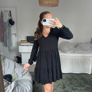 Svart klänning - Supersöt svart klänning med v-ringning och långa ärmar. Aldrig använd. Klänningen är väldigt luftig och skön, jättesöt nu till sommaren!!💕tveka inte med att skriva till mig om ni har några frågor