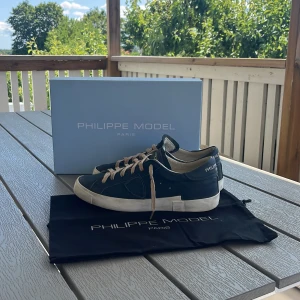 Philippe model skor - Tja, säljer dessa feta pilippe model skor som är i marinblått läder med beiga snören till. Skorna är använda men fortfarande i väldigt bra skick. Det ingår box och dusterbag som är som nya. ( om ni har fler frågor är det bara att skriva till mig)