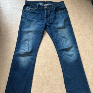Blå bootcut jeans från LTB - Snygga blå jeans från LTB med   bootcut-ben. Jeansen har en mörk tvätt med lätt slitning framtill och bakfickor med dekorativa sömmar. Skriv om du har mer frågor. Pris går att diskutera