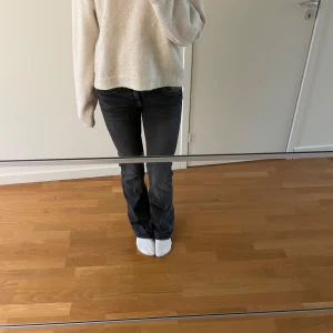 Mörkgrå bootcut jeans - Snygga mörkgrå jeans med bootcut passform och klassisk femficksdesign. Jeansen har en lätt tvättad look och är lådmidjade med utsvängda ben. 