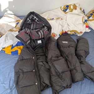 Svart pufferjacka från Burberry - Burberry jacka med bortdragna armar i bra skick. Jätte skön väst till höst och vår. (Jackan är varm på vintern) det passar både M och S. 