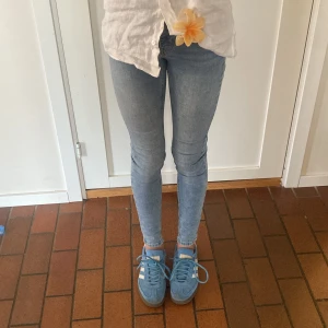 Ljusblå skinny jeans med stretch Gina tricot - Säljer ett par ljusblå skinny jeans med tight passform och klassiska fem fickor. Jeansen heter Molly och har hög midja och är tillverkade i stretchigt denim för en bekväm känsla. Perfekta för dig som gillar en slimmad look och vill ha ett par jeans som sitter snyggt hela dagen.