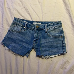 Blå jeansshorts från 365 - Snygga blå jeansshorts från 365, fransiga kanter och klassisk femficksmodell. Shortsen har låg midja och är gjorda i mjukt denimtyg. Perfekta för sommardagar och ger en avslappnad vibe till din outfit. Väldigt lågmidjade, säljer pga för att dem är för små💞