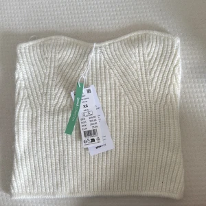 Vit stickad tubtopp från Gina Tricot - Superfin vit stickad tubtopp från Gina Tricot. Toppen är ribbstickad med snygg struktur och bandeau-modell som sitter bekvämt. Storlek XS
