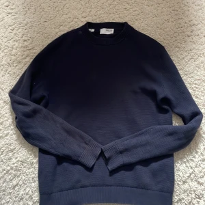 Mörkblå stickad tröja Selected Homme - En stilren mörkblå stickad tröja från Selected Homme. Tröjan har rund halsringning, ribbade muddar vid ärmslut och nederkant samt långärmad passform. Perfekt för lager-på-lager och enkel att matcha med jeans eller chinos.