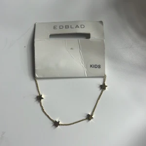 Guldhalsband med stjärnor från Edblad - Superfint halsband i guld från Edblad med små stjärnor längs kedjan. Aldrig andvänt pågrund av att jag inte andvänder guld smycken, armbandet är i barn storlek