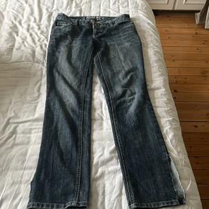 Blå bootcut jeans Mossimo Supply Co - Snygga blå jeans från Mossimo Supply Co med bootcut passform och slitsar nertill på benen. Klassisk femficksmodell med dragkedja och knapp. Jeansen har en cool tvättad look och är gjorda i mjukt denimtyg. Säljer då de är för små på mig💞