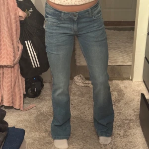 Blå bootcut jeans midwaist - Säljer ett par klassiska blå jeans med bootcut-modell och midwaist. Jeansen har fem fickor, dragkedja och knapp framtill. Perfekta för dig som gillar en tidlös look med lite utsvängda ben. Materialet är mjukt och följsamt jeans. Från Lee, helt oanvända! Modellen kallas Jessica 