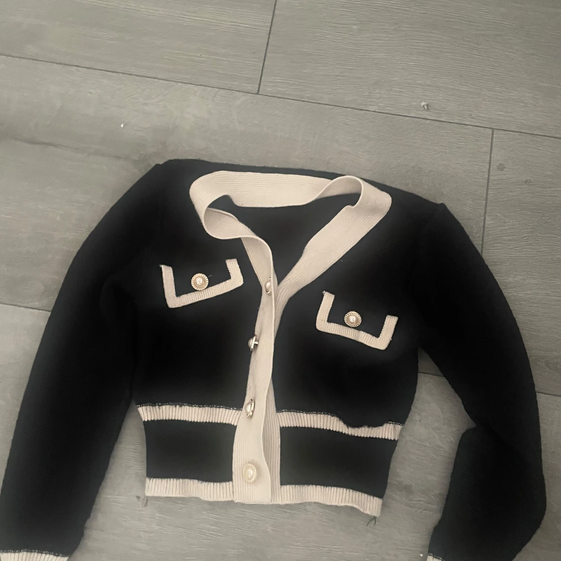 Svart och beige kofta med pärlknappar