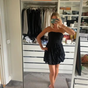 Svart klänning  - Så fin klänning i svart med en rosett, ballongkjol. 