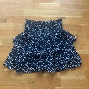 Svartvit volangkjol från Made by Chelsea - Supersöt kort kjol från Made by Chelsea i svart med vita prickar. 