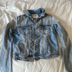 Ljusblå jeansjacka från Zara TRF S - Snygg ljusblå jeansjacka från Zara TRF i storlek S. Klassisk modell med bröstfickor, knappar framtill och kontrastsömmar. Jackan är i 100% denim och har en tidlös vibe. Skulle dock säga att storleken upplevs mindre! Därför rekommenderas köparen att vanligtvis bära xs💕
