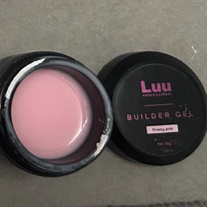 Luu Builder Gel Frosty Pink - Ljusrosa builder gel från Luu Professional i nyansen Frosty Pink. Perfekt för att bygga och forma naglar med en snygg, mjuk rosa finish. Kommer i en svart rund burk med skruvlock och rymmer 30g gel.