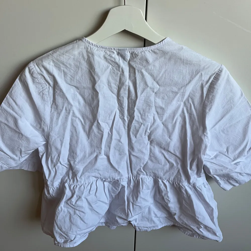 En vit blus med knyte fram till från H&M Säljer då den är för liten, sparsamt anländ. Puserot.