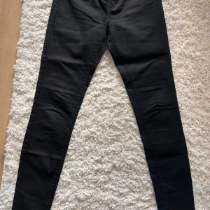 Svarta treggings från Denim Rules - Snygga svarta treggings från Denim Rules. Perfekta för en stilren look. Byxorna har fickor bak. Stl 38