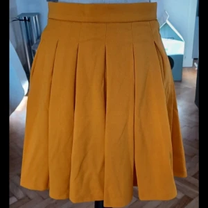 Gul kjol från Shein - Säljer en solgul kjol från Shein med veckad design och dragkedja i sidan. Aldrig använd.